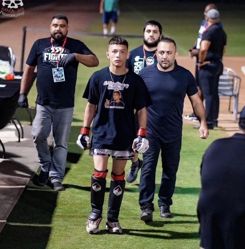 Madera Martial Arts coaches walking with a young fighter at an event